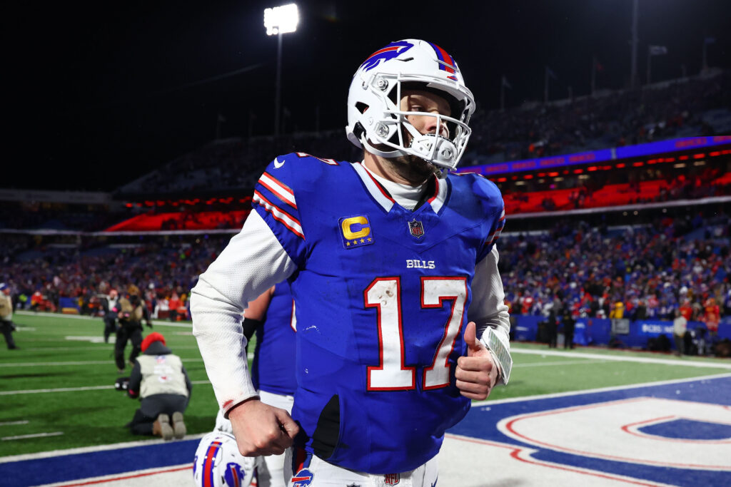 Josh Allen, in his helmet and a blue jersey, runs off the field after a game