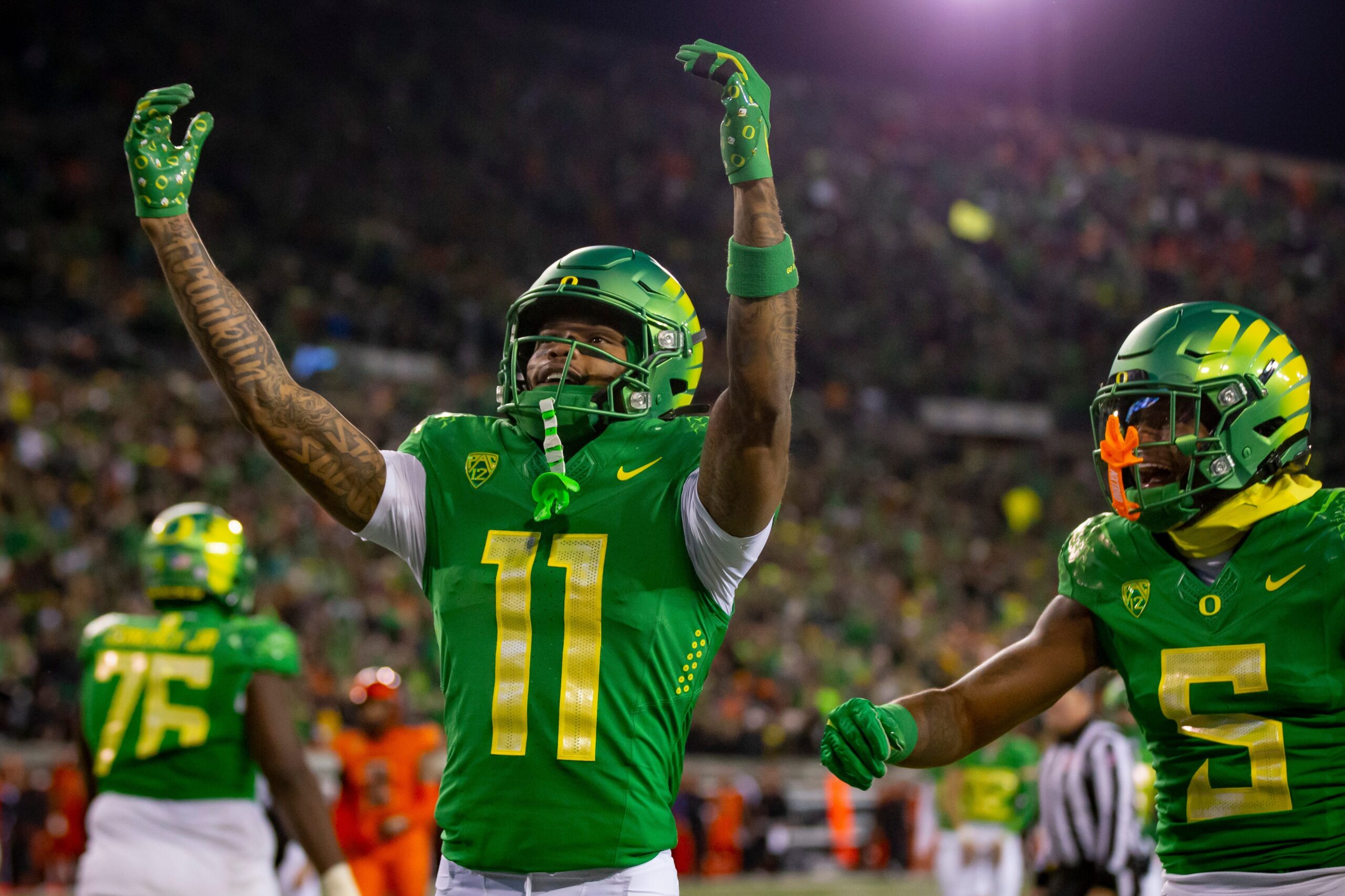 Oregon Ducks WR Troy Franklin raises his arms to the crowd