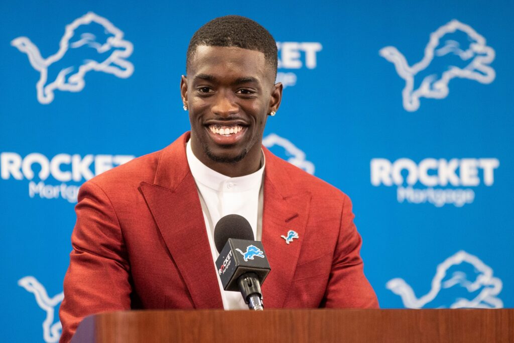 Terrion Arnold speaks at the podium in front of a Detroit Lions background