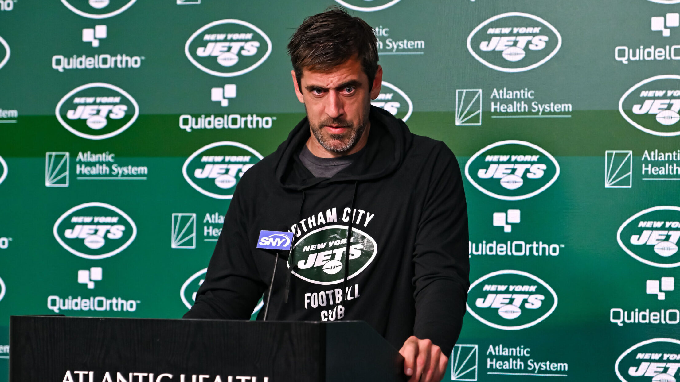 Aaron Rodgers makes a face during a press conference.