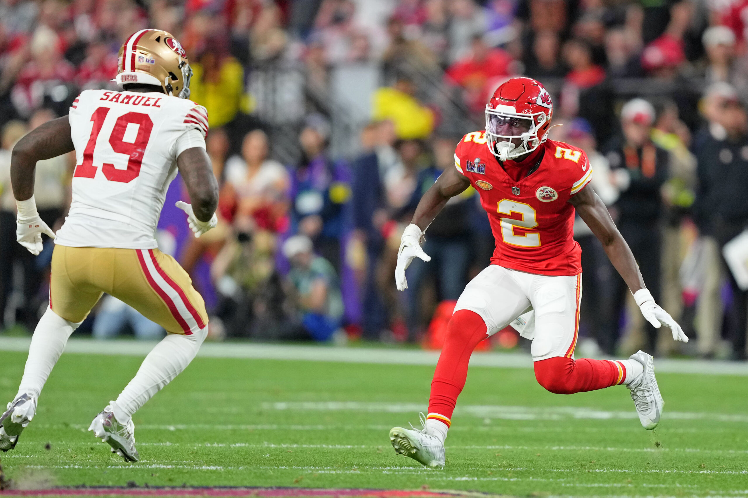 Kansas City CB Joshua Williams (red jersey, helmet and socks; white pants) gets into a defensive stance in the open field with an opposing player in his line of sight