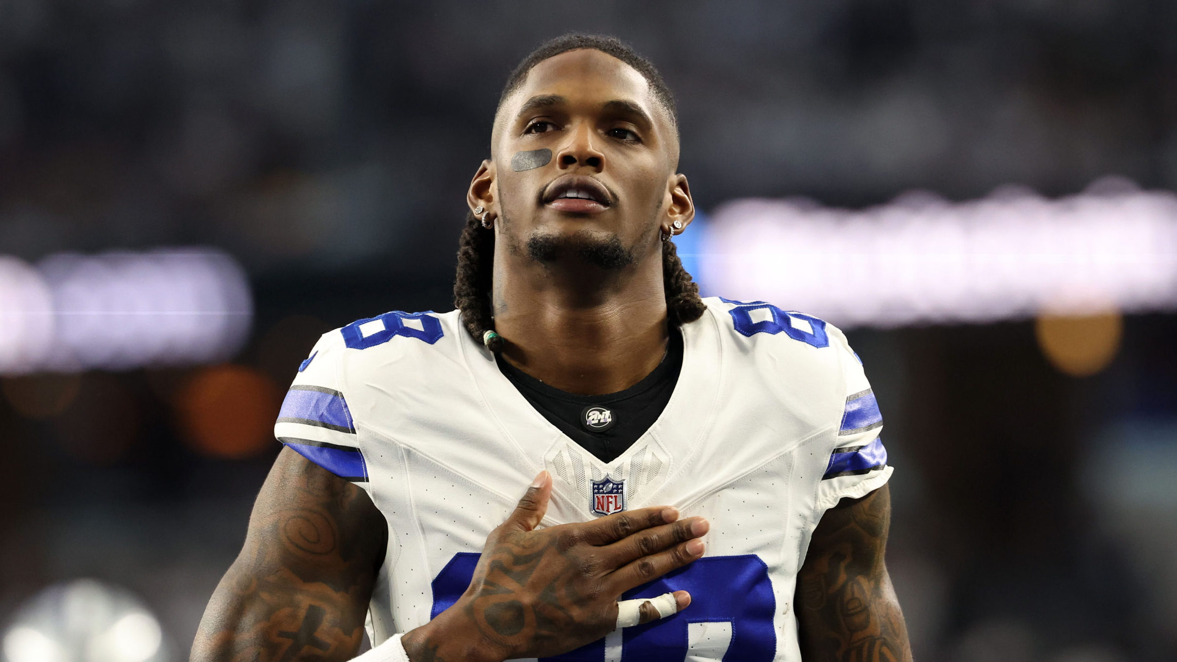 Cowboys WR CeeDee Lamb walks with helmet off and hand over his chest