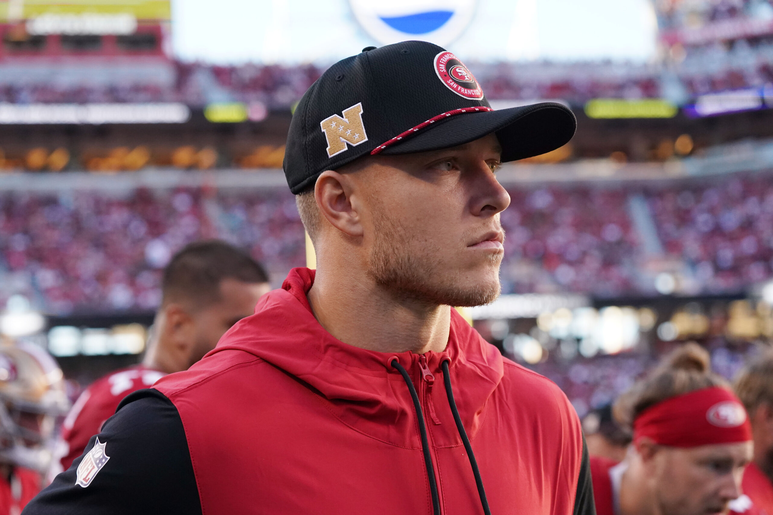 Christian McCaffrey stands on the sideline with his street clothes on.
