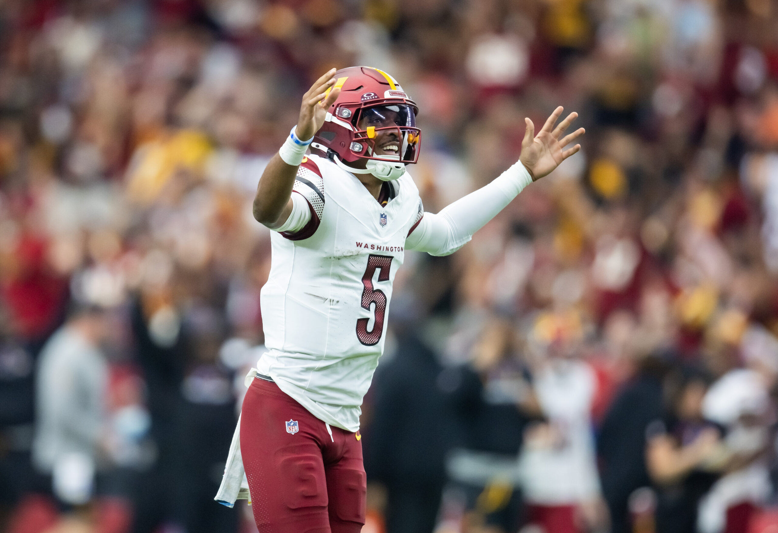 Washington Commanders quarterback Jayden Daniels (5) celebrates a touchdown against the Arizona Cardinals in the first half at State Farm Stadium.