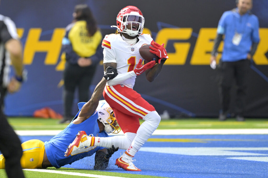 Kansas City Chiefs wide receiver Xavier Worthy is defended by Los Angeles Chargers cornerback Kristian Fulton as he hangs on to a touchdown pass in the first half at SoFi Stadium. 