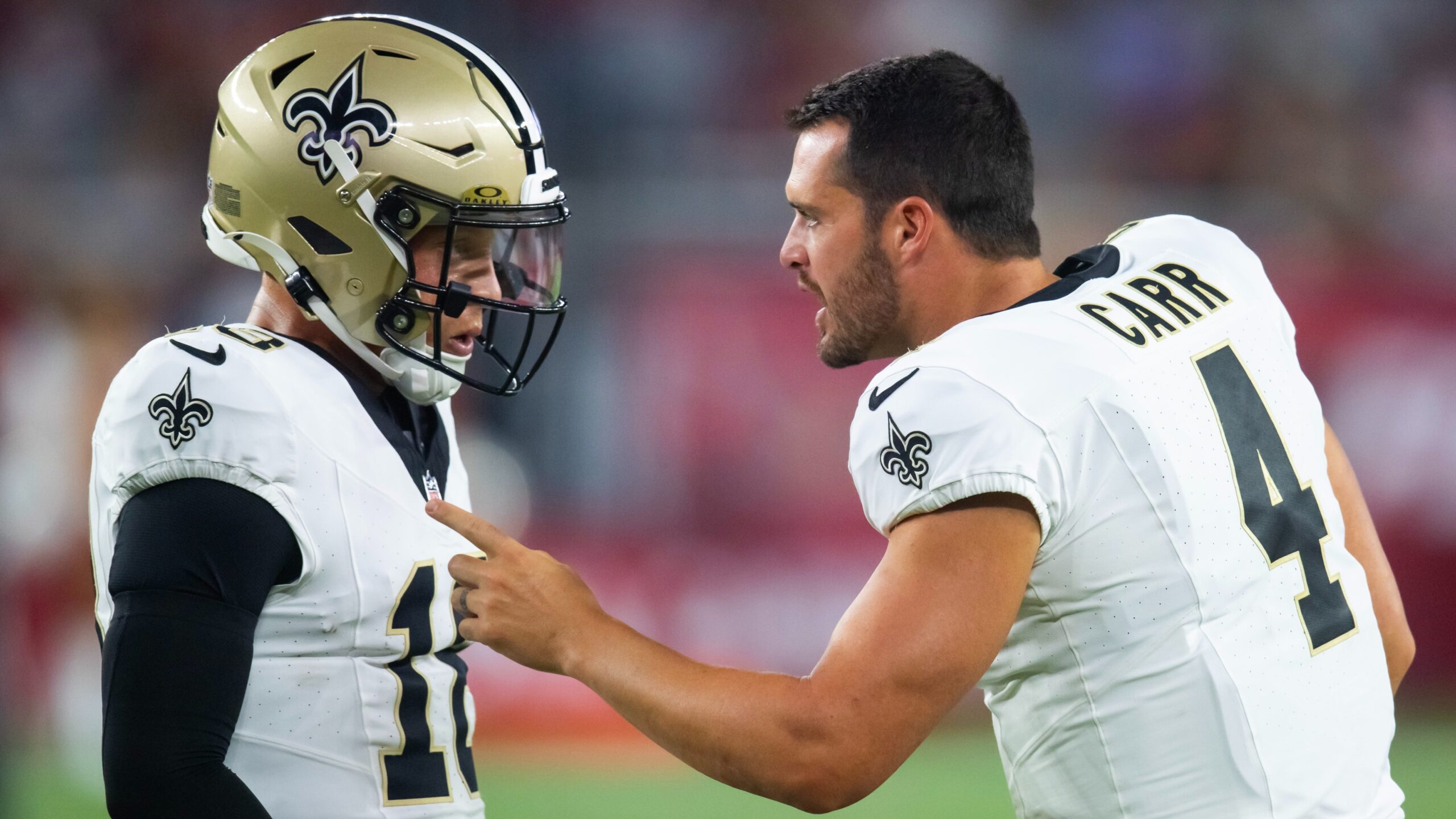 Derek Carr points and talks to Spencer Rattler
