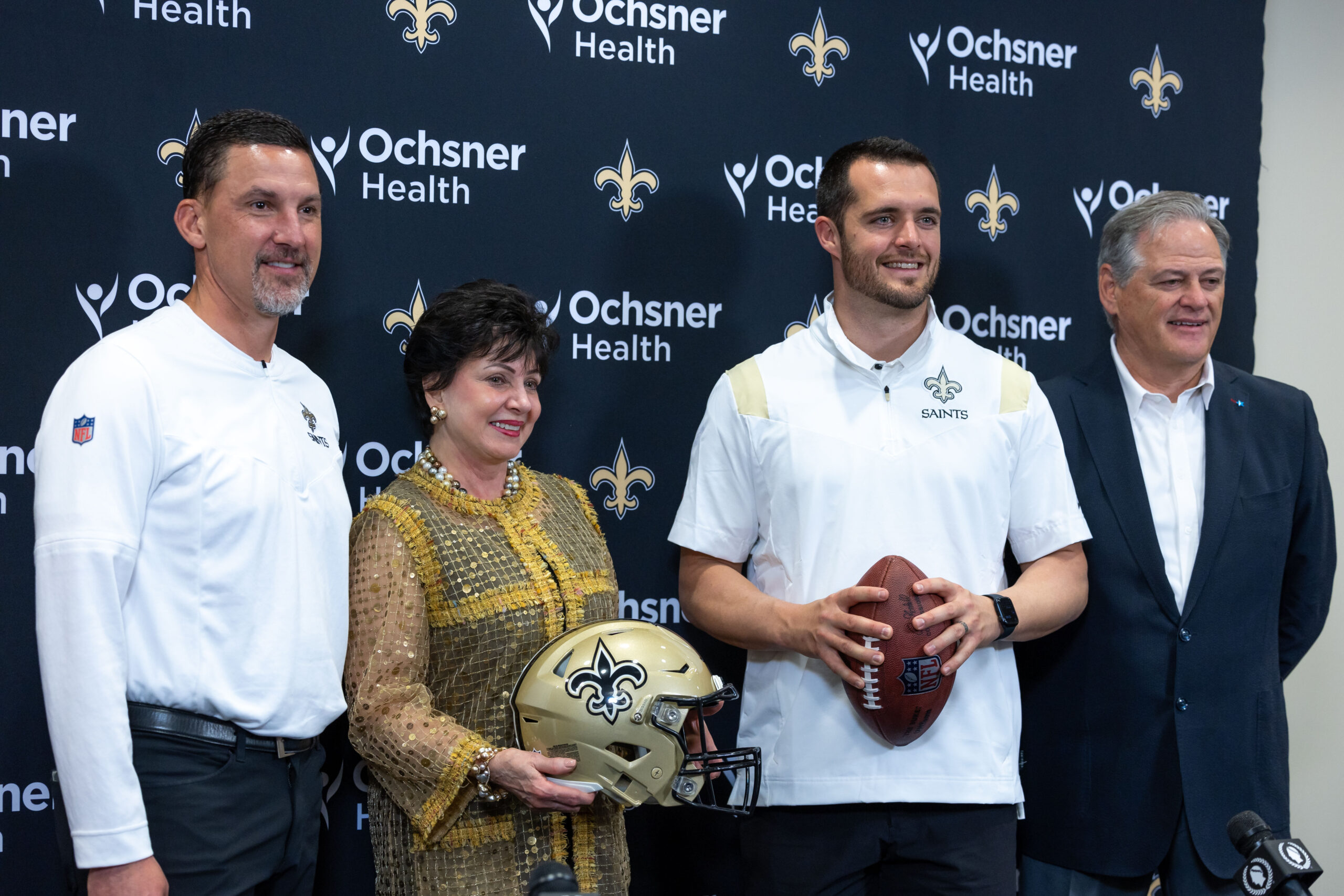 New Orleans Saints head coach Dennis Allen and chief executive officer Gayle Benson and quarterback Derek Carr and general manager Mickey Loomis pose at Ochsner Sports Performance Center.