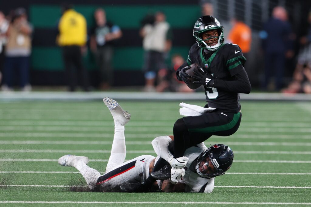 New York Jets wide receiver Garrett Wilson (5) is tackled by Houston Texans safety Jalen Pitre (5) during the second half at MetLife Stadium. Ed Mulholland-Imagn Images