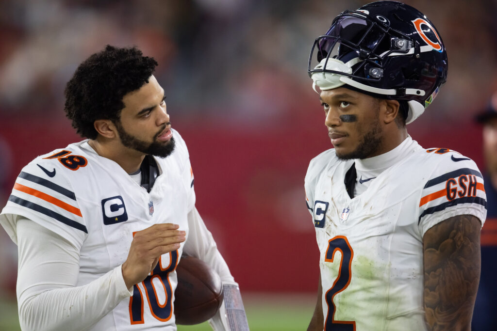 Chicago Bears quarterback Caleb Williams (18) talks with wide receiver DJ Moore (2) against the Arizona Cardinals at State Farm Stadium. 