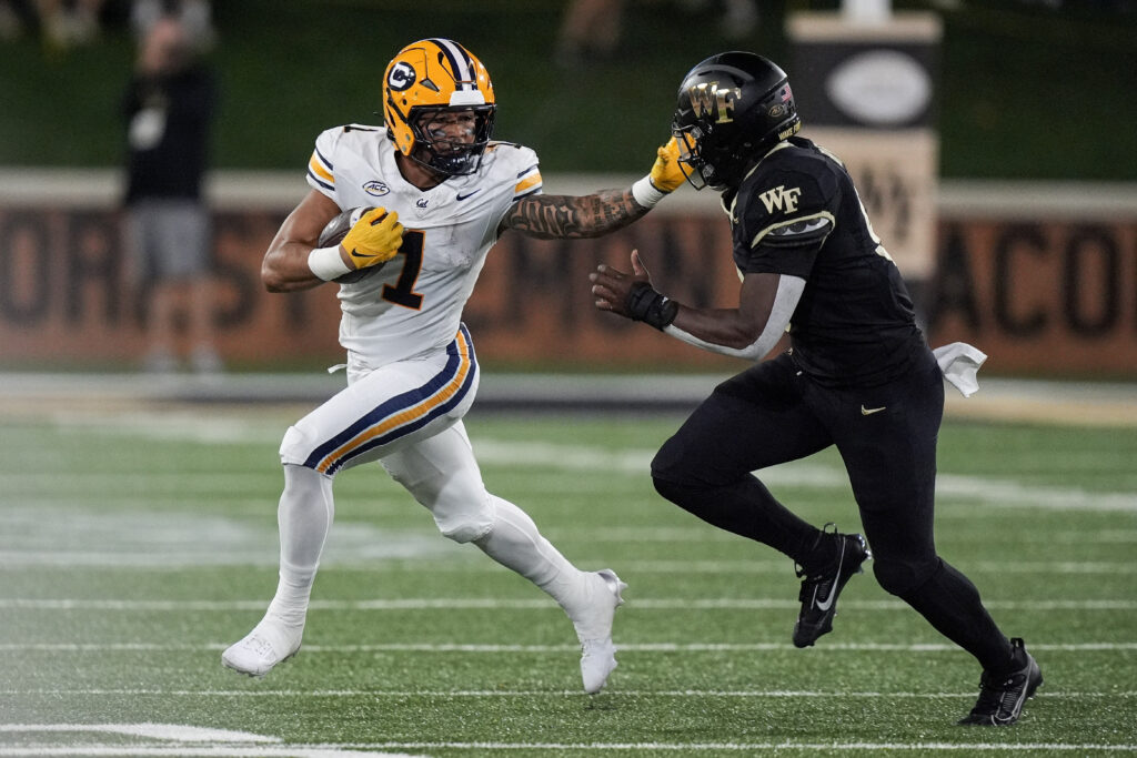 California Golden Bears running back Jaydn Ott stiff arms Wake Forest Demon Deacons linebacker Quincy Bryant during the first half at Allegacy Federal Credit Union Stadium. 