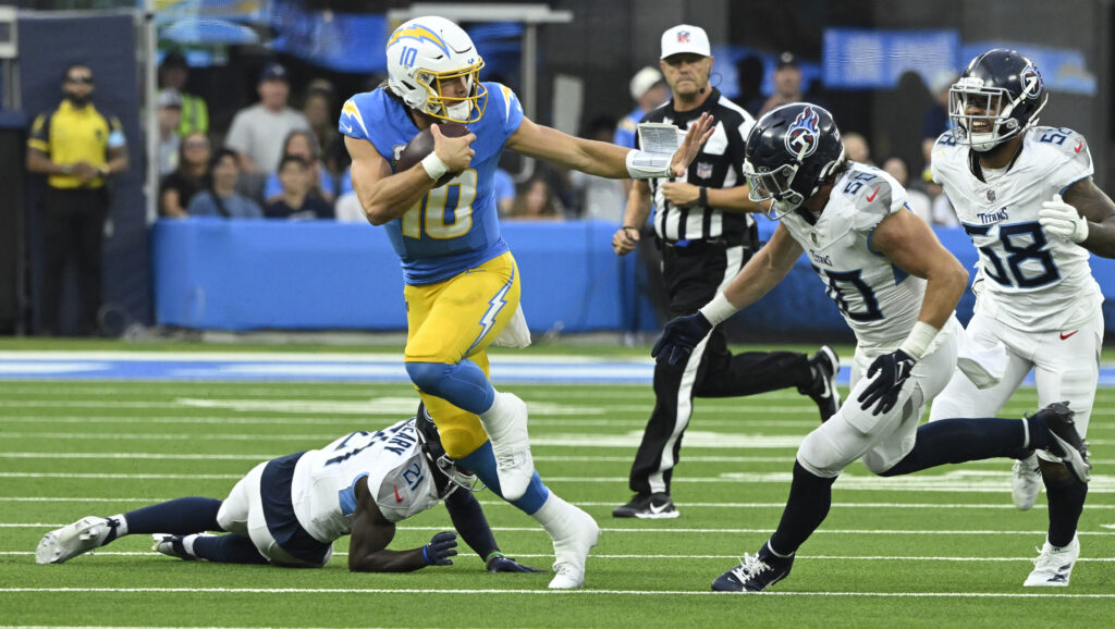Los Angeles Chargers quarterback Justin Herbert tries to run past Tennessee Titans linebacker Jack Gibbens during the third quarter at SoFi Stadium.