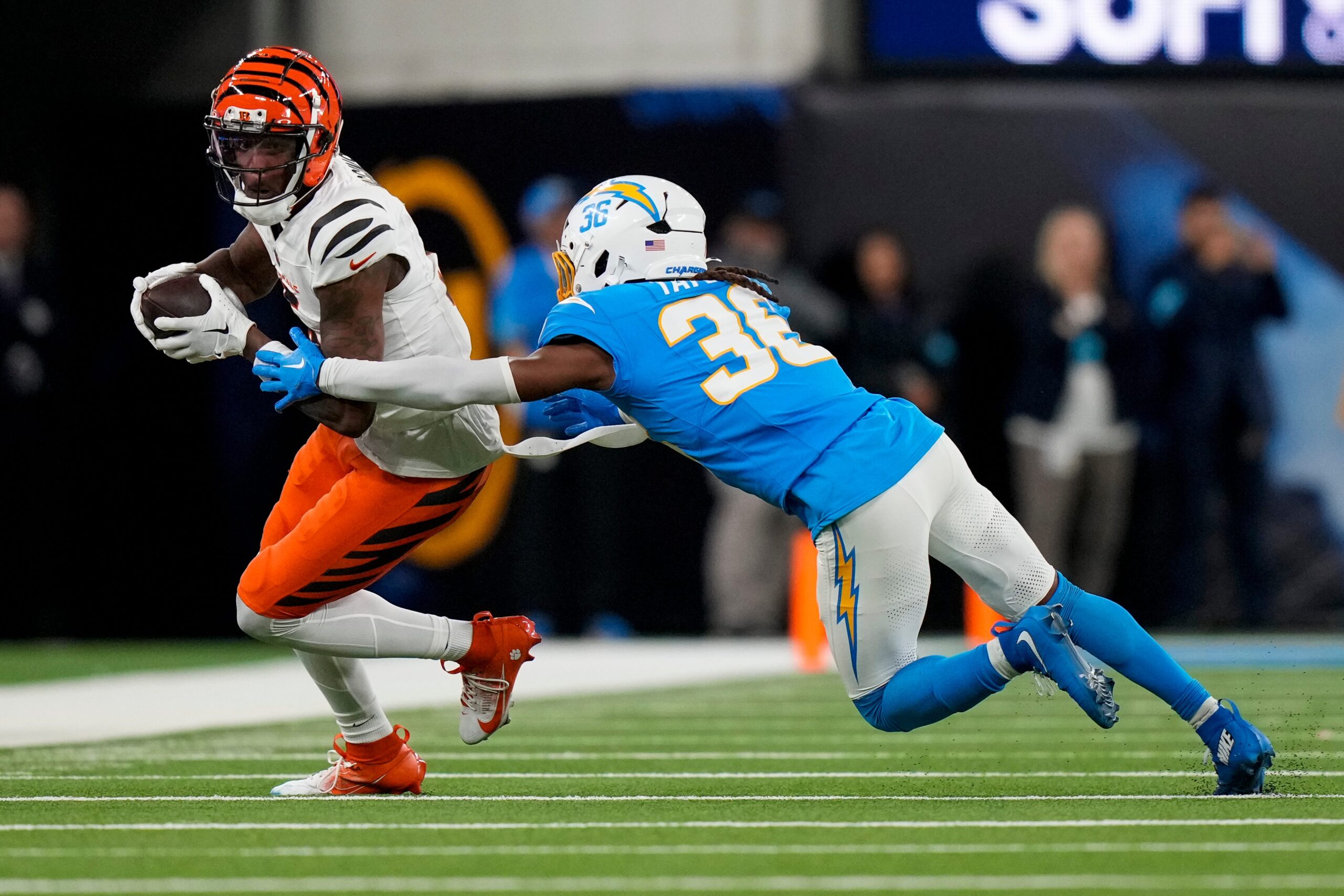 Cincinnati Bengals wide receiver Tee Higgins (5) catches a pass ahead of Los Angeles Chargers cornerback Ja'Sir Taylor (36) in the fourth quarter of the NFL Week 11 game between the Los Angeles Chargers and the Cincinnati Bengals