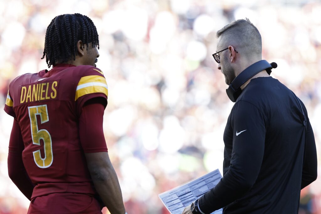 Washington Commanders quarterback Jayden Daniels (5) talks with Commanders offensive coordinator Kliff Kingsbury (R) during a timeout Dallas Cowboys.