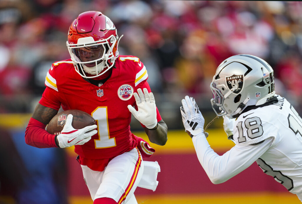 Kansas City Chiefs wide receiver Xavier Worthy (1) runs with the ball against Las Vegas Raiders cornerback Darnay Holmes (30) during the first half at GEHA Field at Arrowhead Stadium.