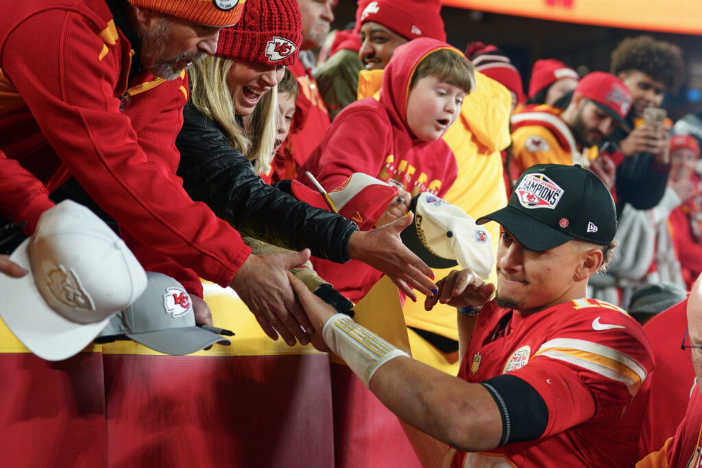 Kansas City Chiefs quarterback Patrick Mahomes (15) greets fans while leaving the field after the win over the Los Angeles Chargers at GEHA Field at Arrowhead Stadium.