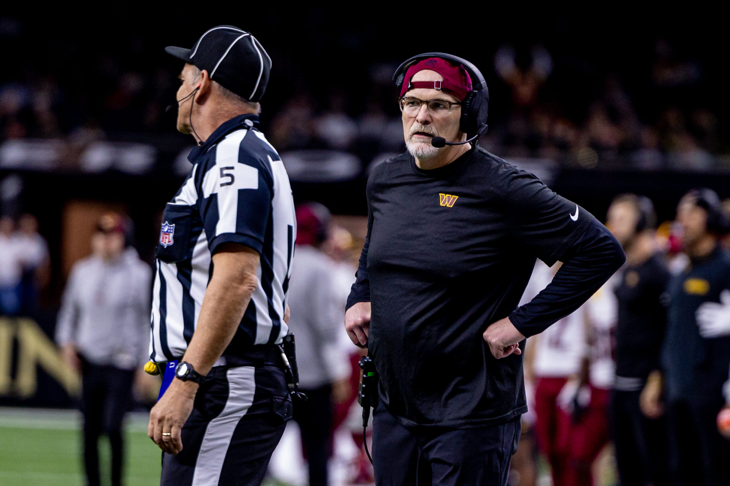 Washington Commanders head coach Dan Quinn talks to side judge Jim Quirk (5) against the New Orleans Saints during the first half at Caesars Superdome.