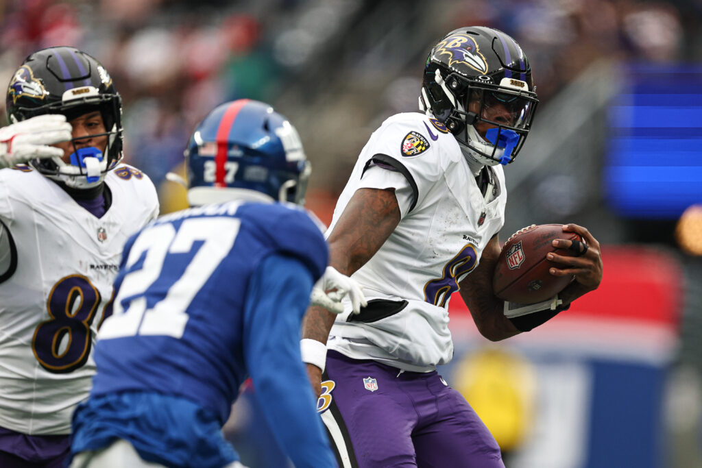 Baltimore Ravens quarterback Lamar Jackson (8) carries the ball as New York Giants safety Jason Pinnock (27) pursues during the first half at MetLife Stadium.
