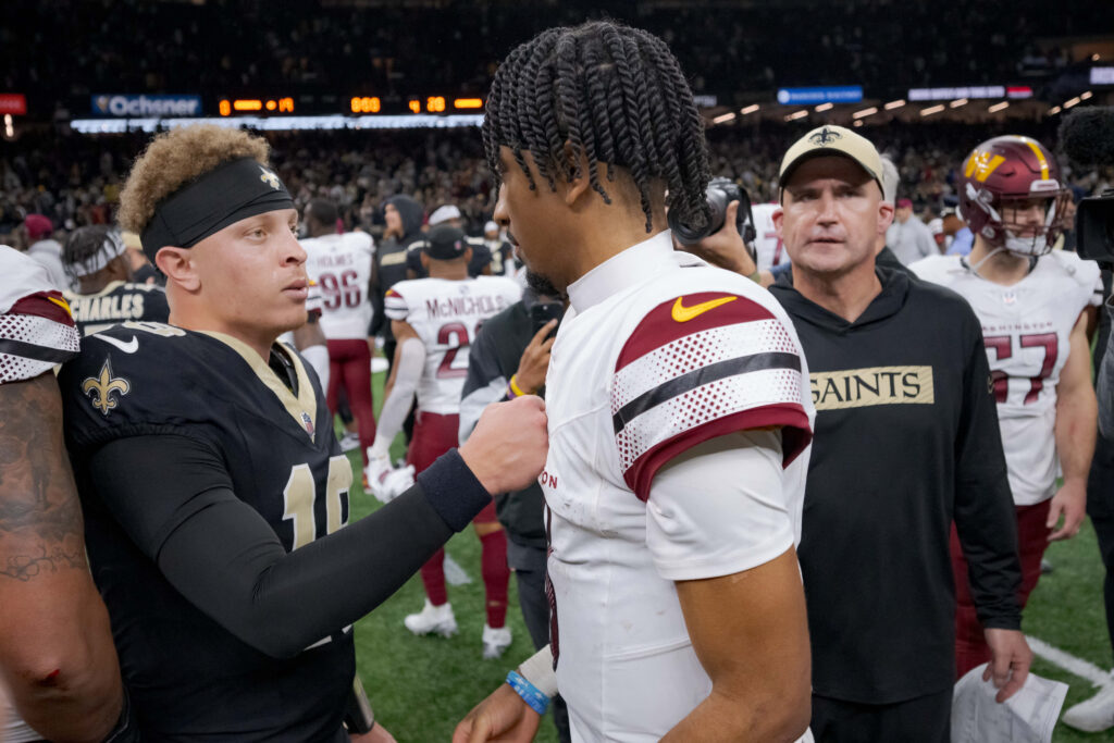 New Orleans Saints quarterback Spencer Rattler (18) talks to Washington Commanders quarterback Jayden Daniels (5) at the end of the game. 