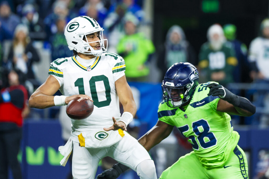 Green Bay Packers quarterback Jordan Love (10) passes while under pressure from Seattle Seahawks linebacker Derick Hall (58) during the second quarter at Lumen Field.