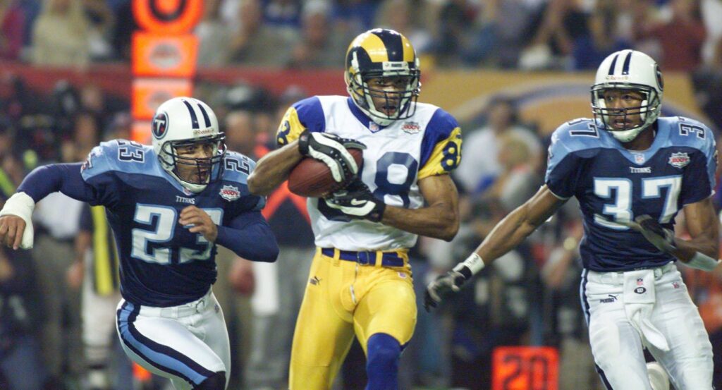 Tennessee Titans defenders Blaine Bishop (23) and Dainon Sidney (37) pursue St. Louis Rams receiver Torry Holt (88) during the second quarter of Super Bowl XXXIV inside the Georgia Dome Jan. 30, 2000.