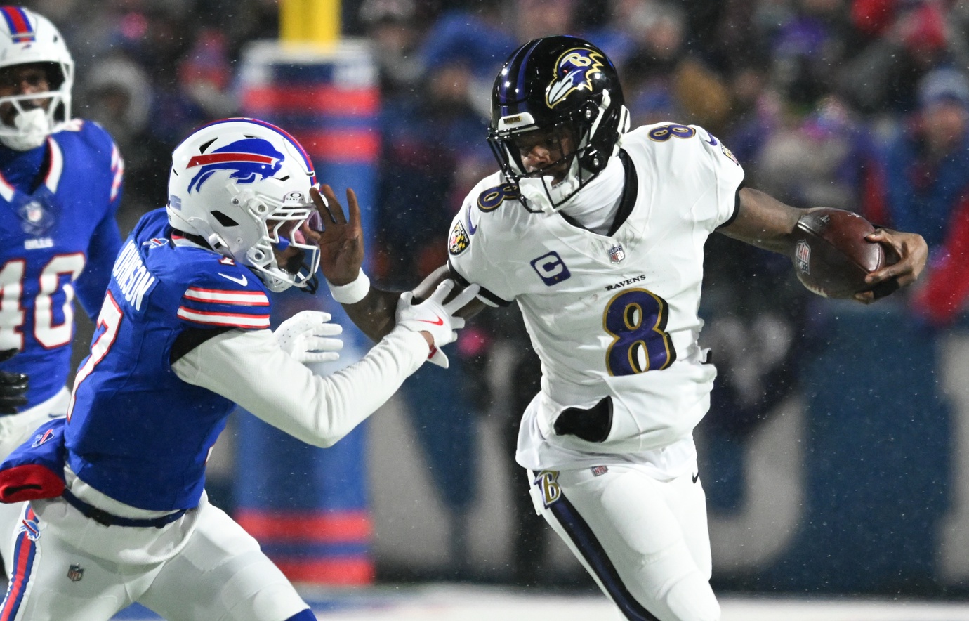 Baltimore Ravens quarterback Lamar Jackson (8) runs the ball against Buffalo Bills cornerback Taron Johnson (7) during the first quarter in a 2025 AFC divisional round game at Highmark Stadium.