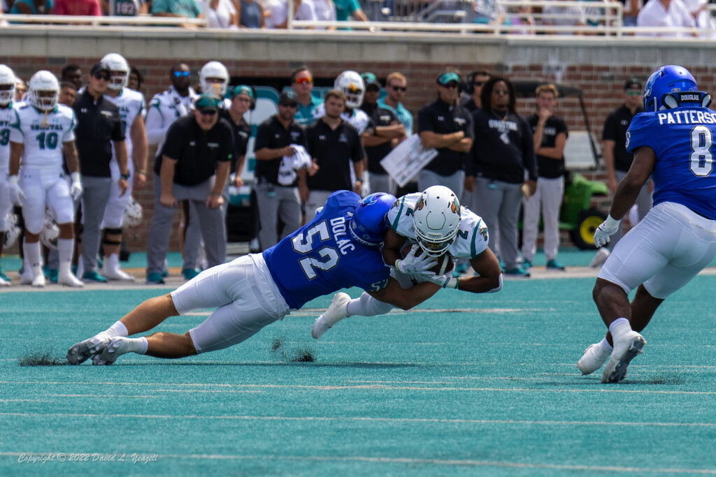 Coastal Carolina Chanticleers running back Reese White (2) is tackled by Buffalo Bulls linebacker Shaun Dolac (52) in the first quarter at Brooks Stadium. 