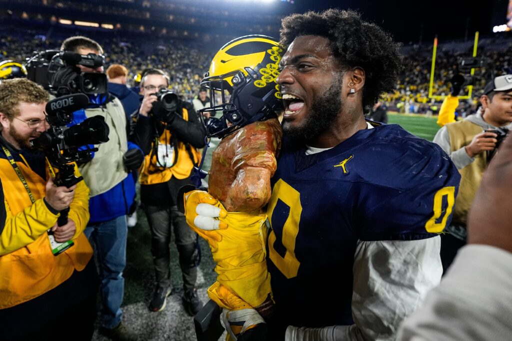 Michigan defensive end Josaiah Stewart (0) celebrates with the Paul Bunyan Trophy after 24-17 win over Michigan State at Michigan Stadium in Ann Arbor.