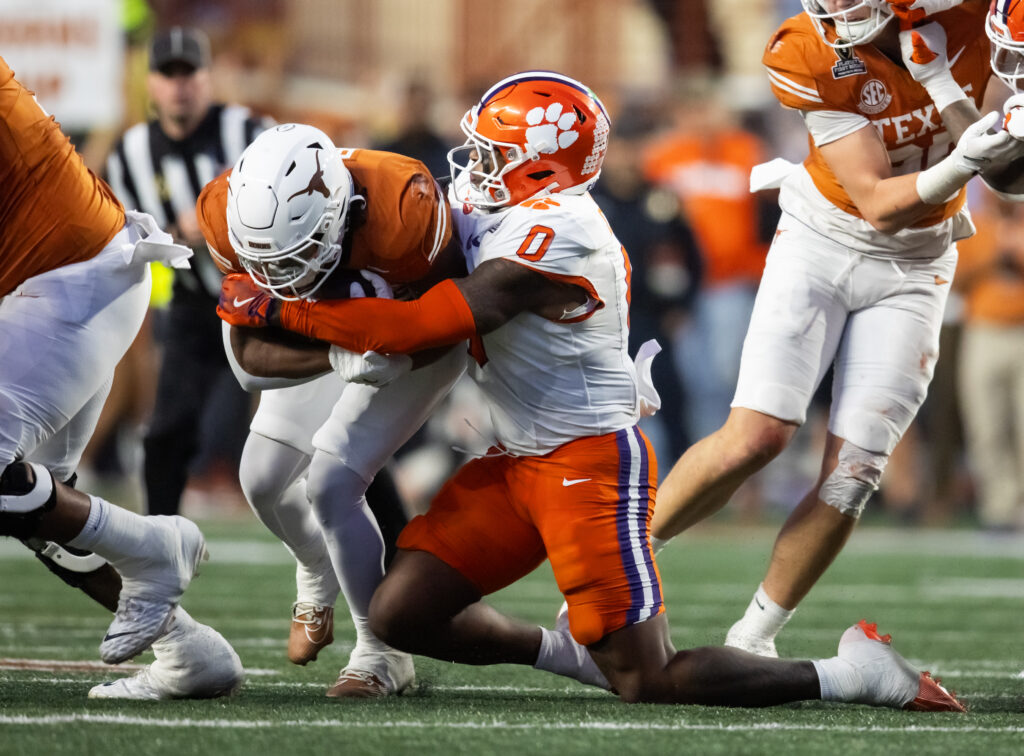 Clemson Tigers linebacker Barrett Carter (0) tackles Texas Longhorns running back Jaydon Blue (23) during the CFP National playoff first round.