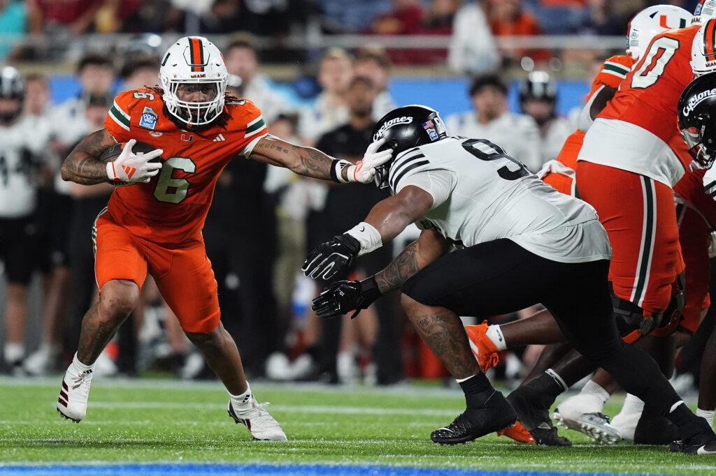 Miami Hurricanes running back Damien Martinez (6) stiff arms Iowa State Cyclones linebacker Cael Brezina (9) during the second half at Camping World Stadium.